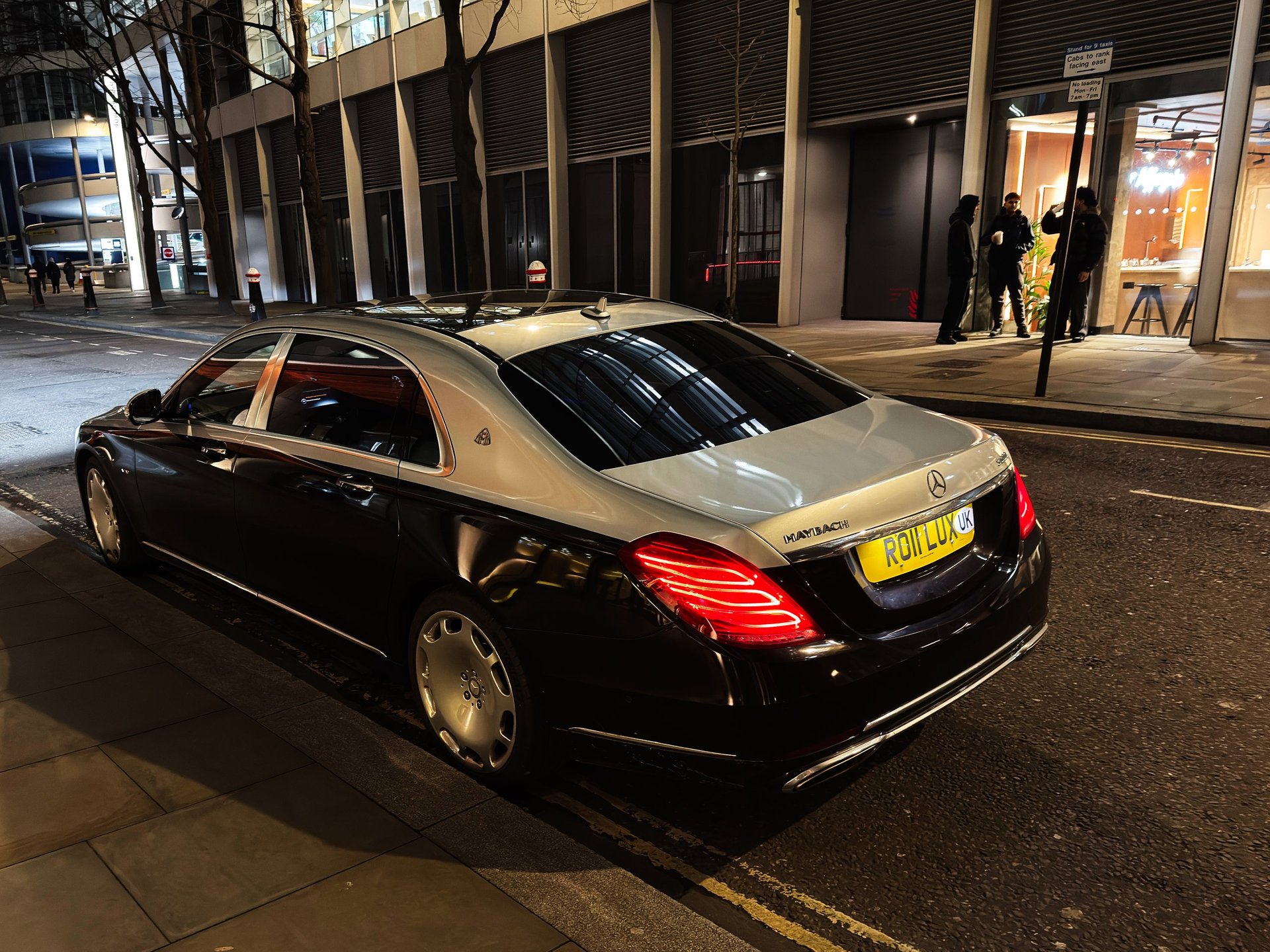 Elegant black and silver Maybach parked on a London street at night